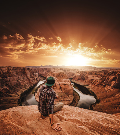 man resting at horseshoe bend in usa