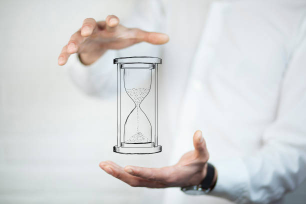 istock Man's hand holding hourglass sand 867150468