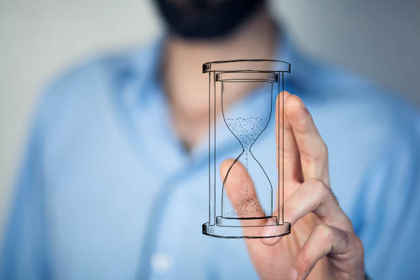 istock Man's hand holding hourglass sand 867150470