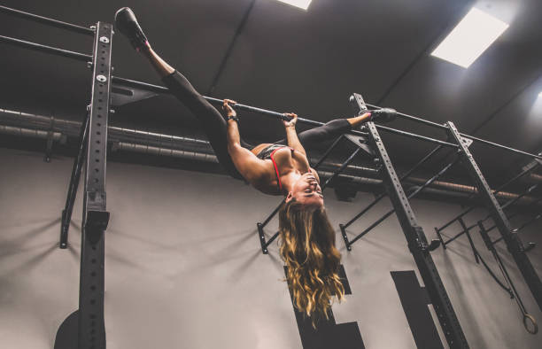 istock Blonde girl with athletic physique during pull ups workout with split, head down 867156160
