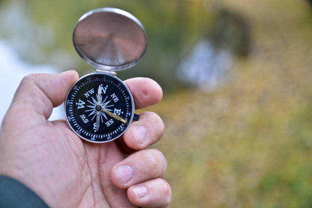 Autumn walk in the wet season. Compass in hand against a background of yellow nature.