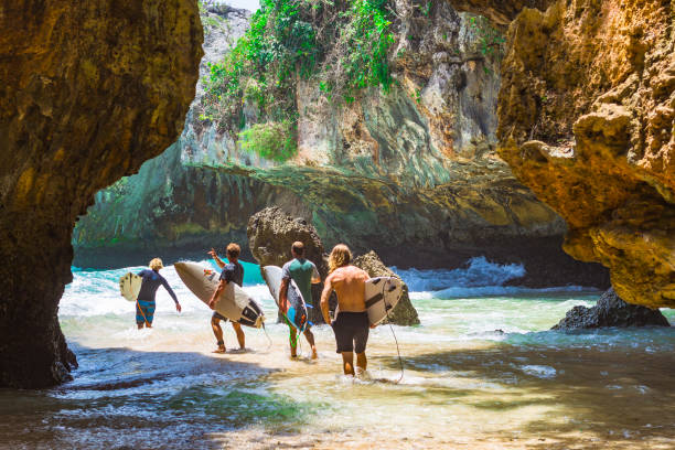 Unidentified surfers at Balangan beach, Bali. stock photo