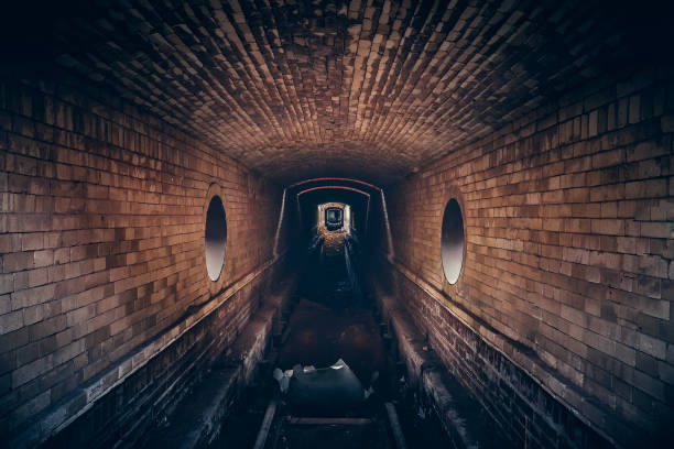 Red brick underground sewer tunnel with dramatic mysterious atmosphere