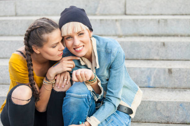 istock Two young women sitting on stairs and talking 867196958