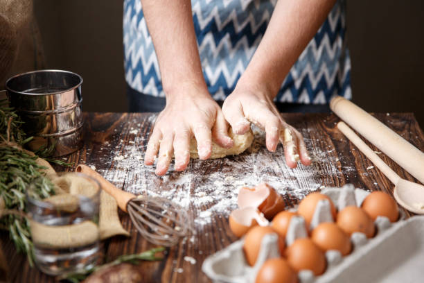 istock A white man makes a dough on the table near the products. 867206638