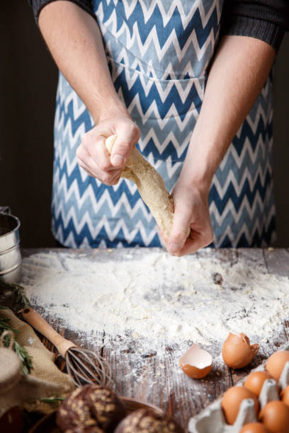 istock A man in an apron tears the dough over the table. 867206940