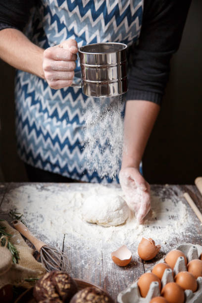 istock The man sprinkles the dough with flour, giving it shape. 867207270