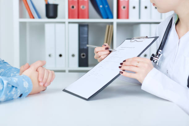 istock Female doctor holding application form while consulting patient. 867212476