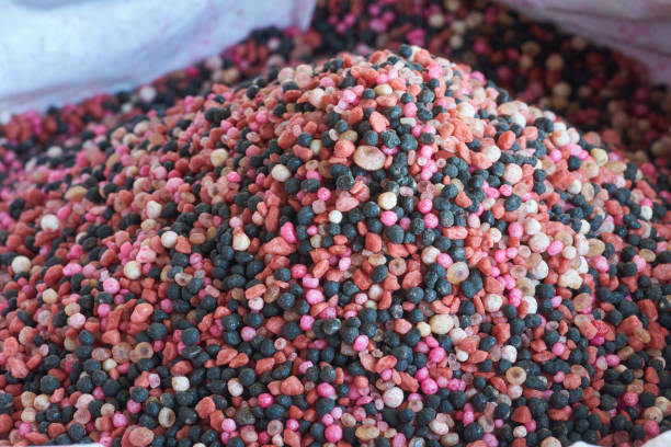 istock a heap of red fertilizer over white fertilizer bag. Nitrogen (N): leaf growth,Phosphorus (P): Development of roots,Potassium (K): Strong stem growth 867225636