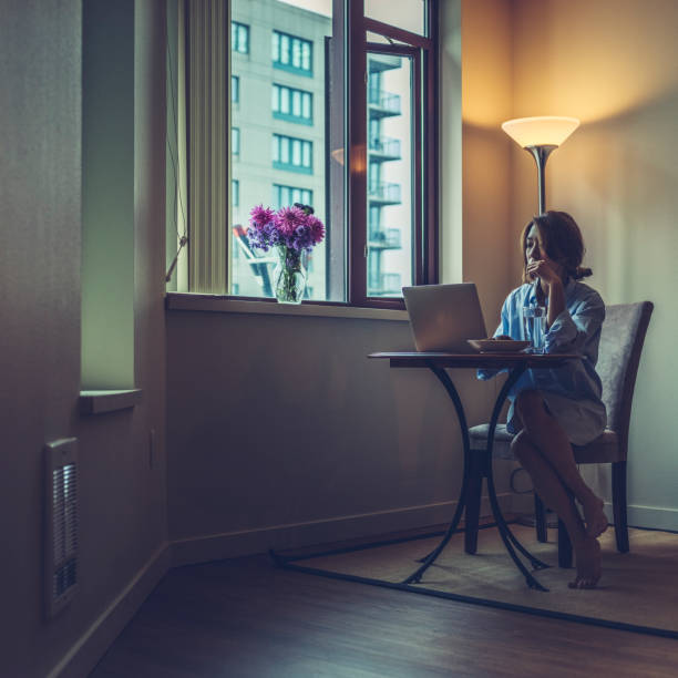 istock woman in shirt using laptop with breakfast on table 867226162