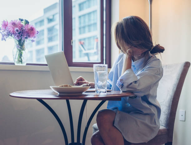 istock woman in shirt using laptop with breakfast on table 867228690