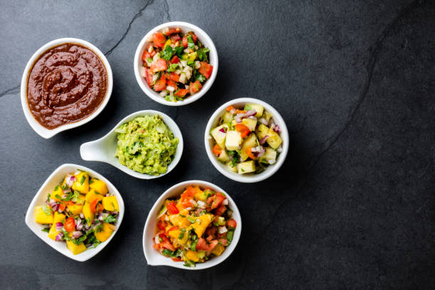 traditional famous mexican sauces chocolate chili mole poblano, pico de gallo, avocado guacamole, salsa bandera, pinapple salsa, mango salsa on slate gray background - guacamole avocado mexican culture food imagens e fotografias de stock