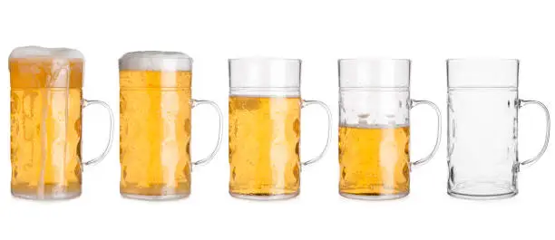 Cutout of five glass mugs with beer sorted from full to empty