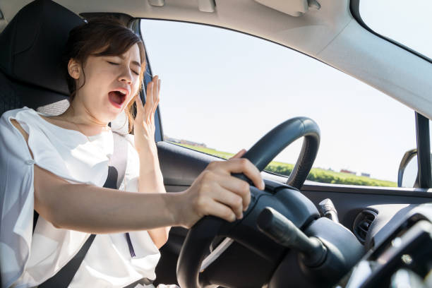 yawning female driver. falling asleep at the wheel concept. yawning female driver. falling asleep at the wheel concept. insufficient funds stock pictures, royalty-free photos & images