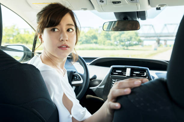 young woman driver turning back.