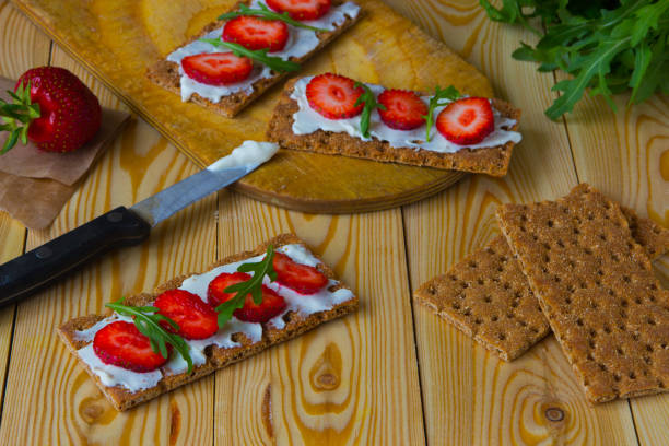 istock Wholegrain rye crispbread crackers with cream cheese, strawberry and arugula 867248298