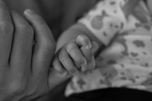 istock Little baby holding dad's finger 867249112