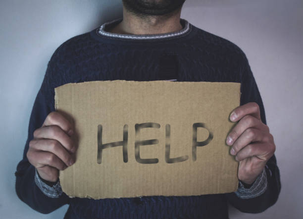 istock Homeless man with help sign. 867260696