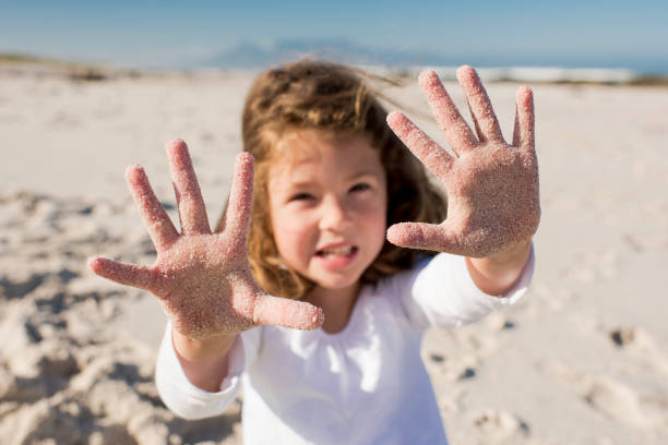istock Little girl shows her sandy hands to camera focus on hands 867277372