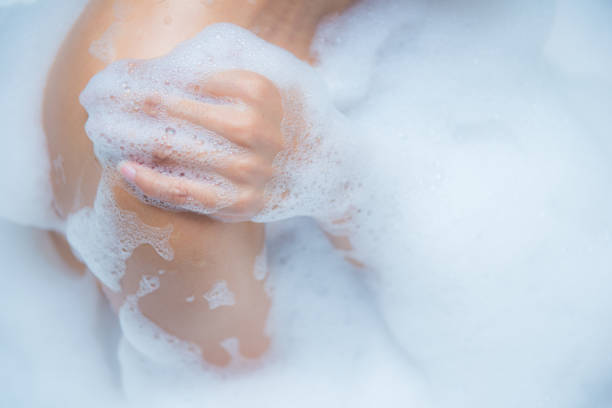 istock Young woman taking a relaxing bath with foam 867284296