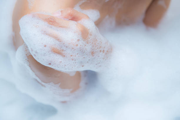 istock Young woman taking a relaxing bath with foam 867285188