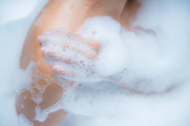 istock Young woman taking a relaxing bath with foam 867285878