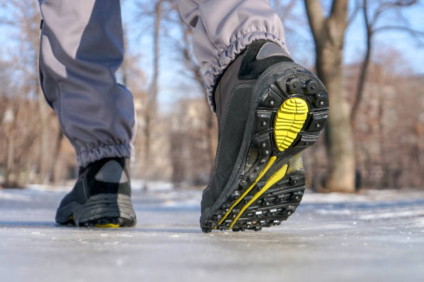 istock Winter legs wearing boots walking on snowy and sleet road 867287278