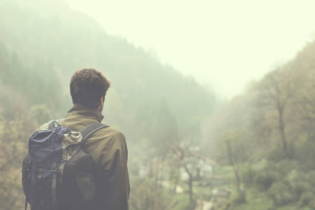 istock hipster hiker walking in a foggy forest 867290938