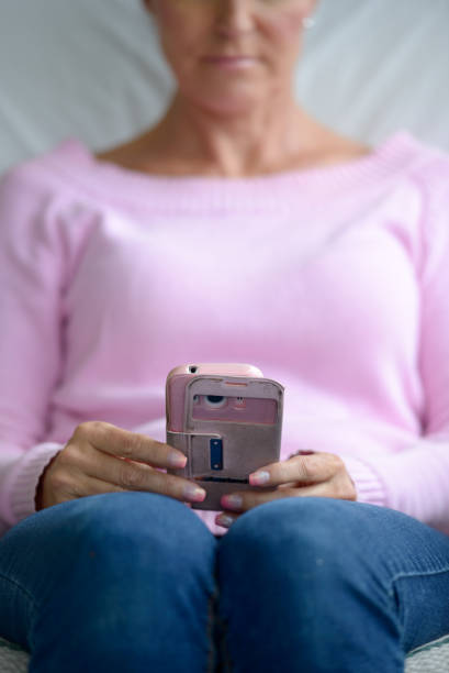 Hands of mature beautiful Finnish woman using mobile phone while relaxing at home in Turku Finland