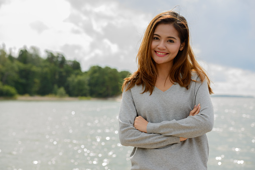 Portrait of young beautiful Asian woman against scenic view of the lake in Turku Finland