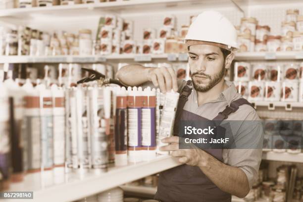Focused Workman Choosing Materials For Renovation Works In Paint Store Stock Photo - Download Image Now