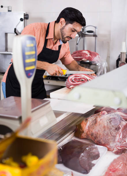 istock Nice butcher is cutting meat for clients 867298196