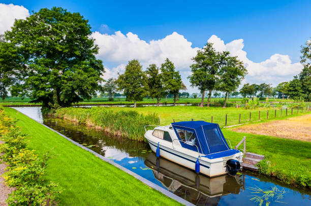 Small Canal with Motorboat in Giethoorn Netherlands on summer day.