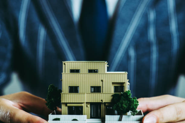 istock Businessman's hand holding a house model 867302048