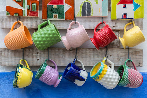 Colorful Empty Cups Hanging on a Wall.