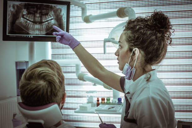 istock Dentist and patient watching X-ray clip. 867305614