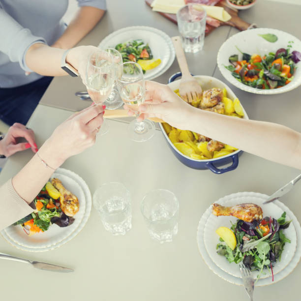 istock Women toasting with champagne while having dinner together 867305616