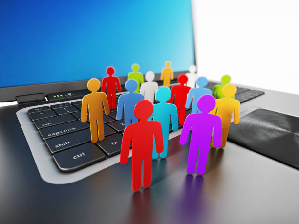 istock Multi-colored group of stick figures standing on laptop computer keyboard 867316128