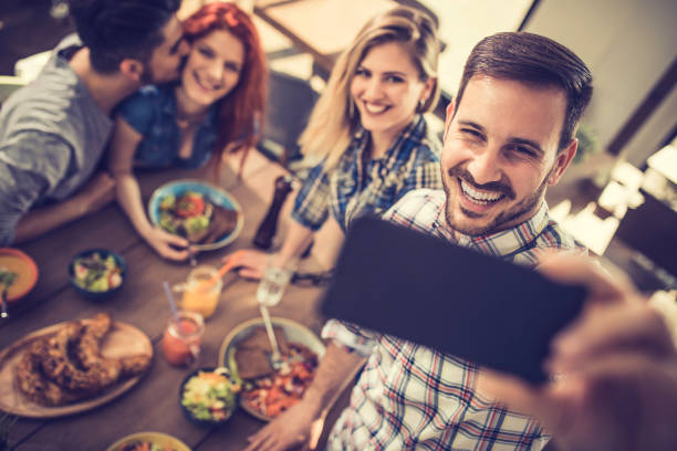 istock Happy man taking a selfie with his friends in a restaurant. 867322142