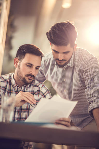 istock Young serious businessmen analyzing reports in the office. 867323030