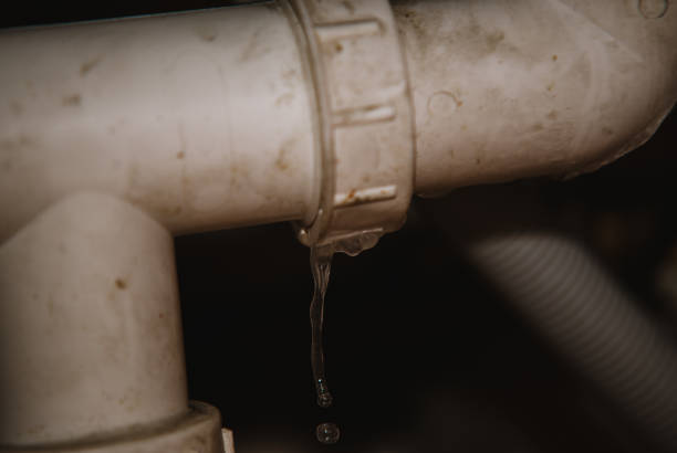 vera perdita d'acqua dal tubo sullo sfondo della casa - foto stock