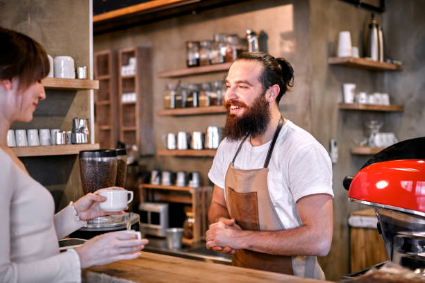 istock Staff Serving Customer In Busy Coffee Shop 867339338