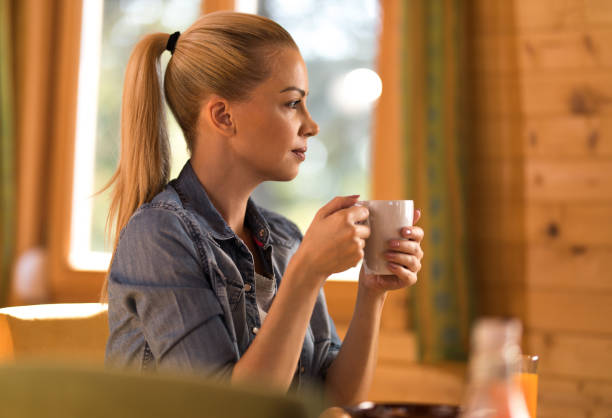 istock Profile view of young pensive woman having her coffee at home. 867345708