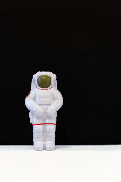 Astronaut soft toy on white floor and black background
