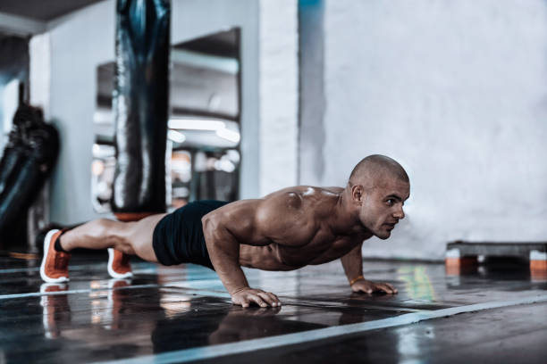istock Man exercising and doing push-ups in the local gym 867348242