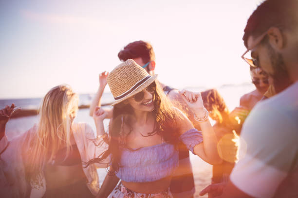 Young hipster friends on summer holidays dancing at beach party Young hipster friends having fun and dancing at summer island beach party at sunset beach party stock pictures, royalty-free photos & images