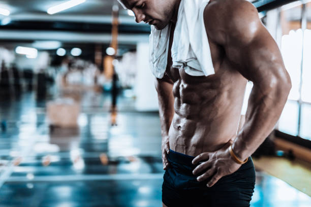 Young man tired after training showing his abdominal muscles stock photo