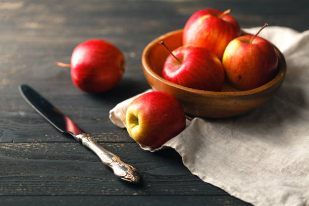 istock Red apples in a wooden bowl on dark background. 867355966