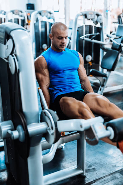 istock Young man exercising legs in the local gym 867359870