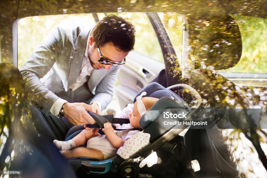 Joven padre a niña ponía en el coche. - Foto de stock de Niño libre de derechos